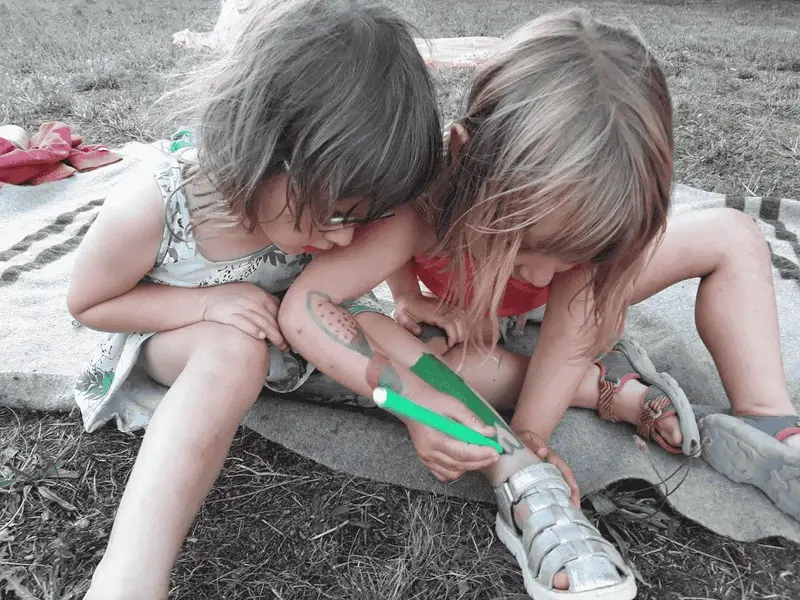 Deux enfants qui jouent avec un feutre vert